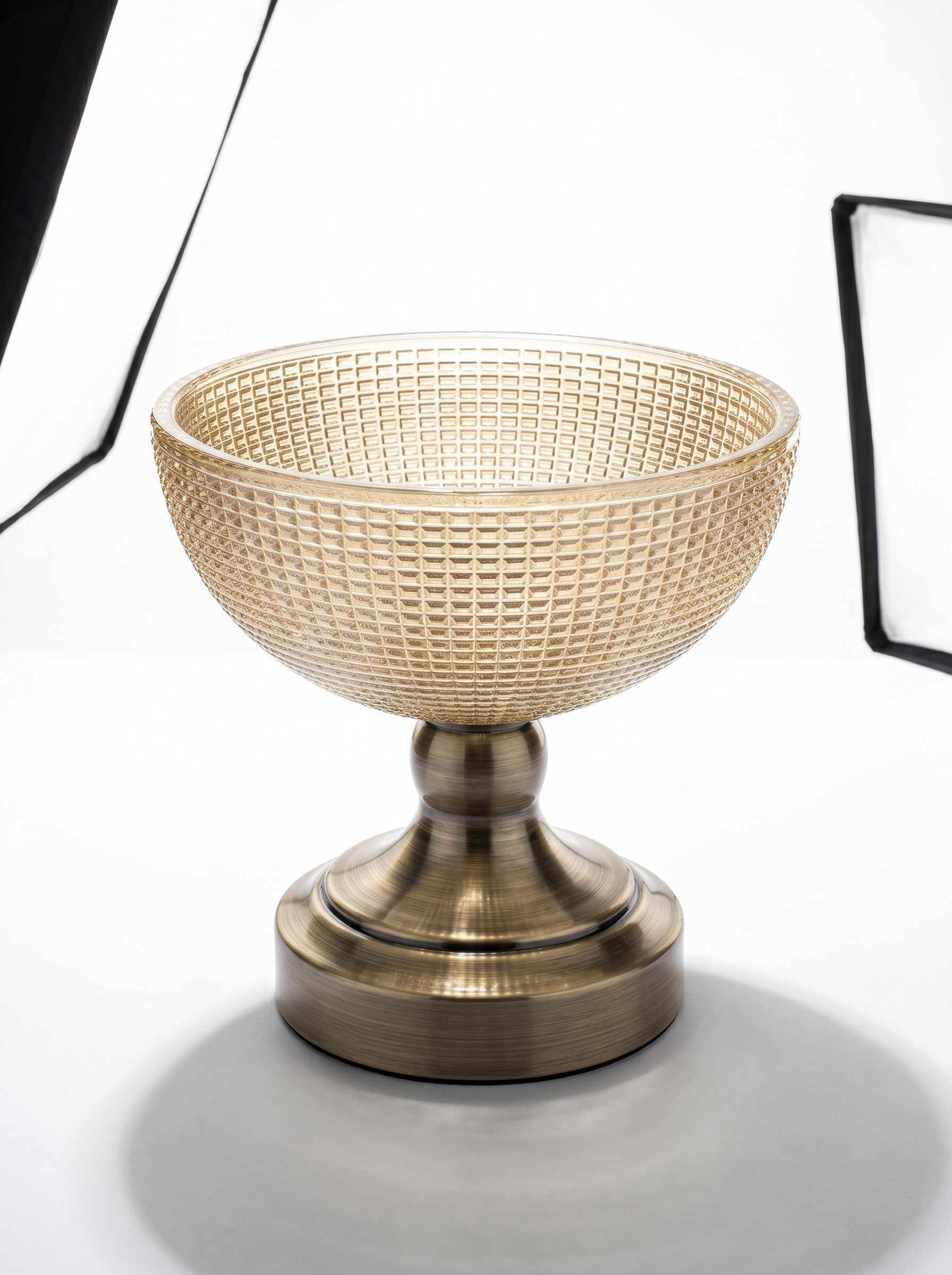 High Objects textured amber glass bowl with a brass pedestal base, perfect for decorative use.