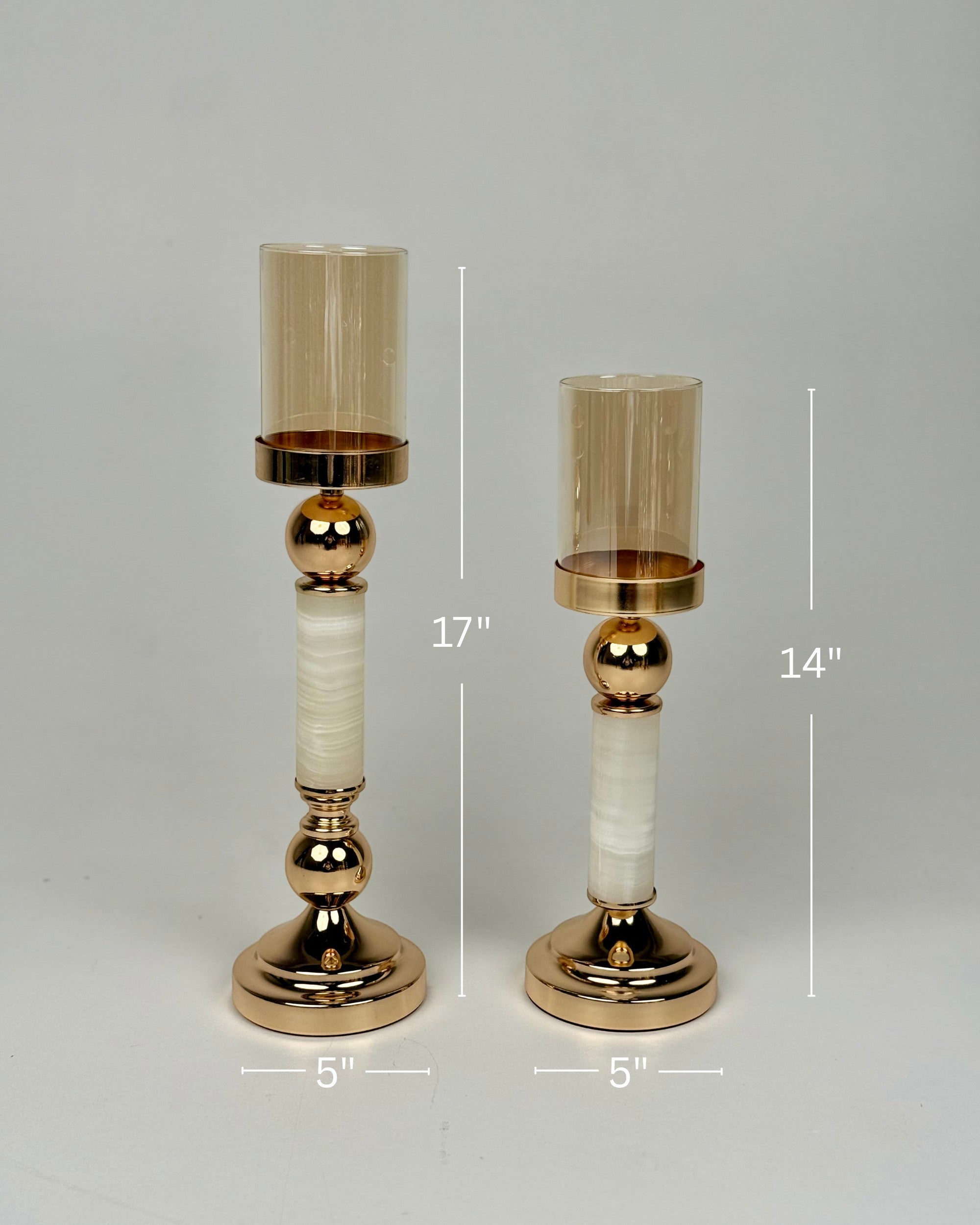 High Objects Aurora Column Candle Stand Set, 17" and 14" tall, with amber glass holders and gold metallic accents on white stone-inspired columns.