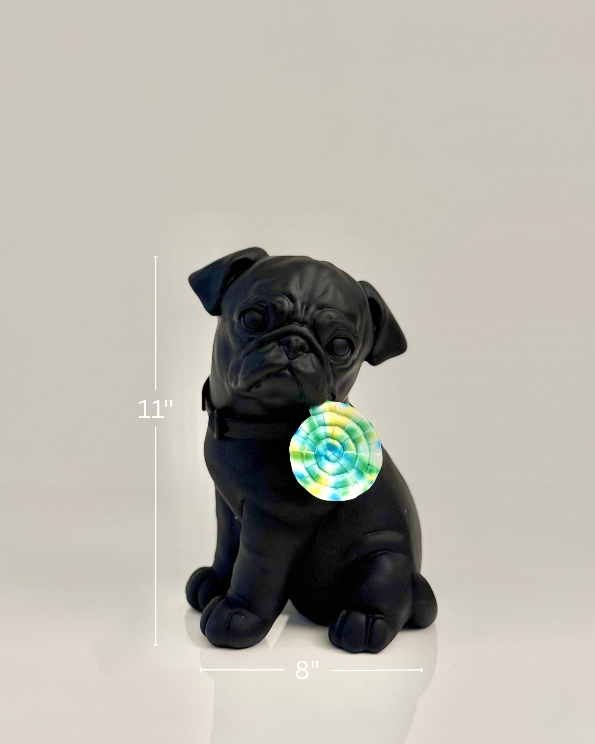 High Objects matte black pug sculpture with a colorful swirl lollipop accent. Modern home decor.