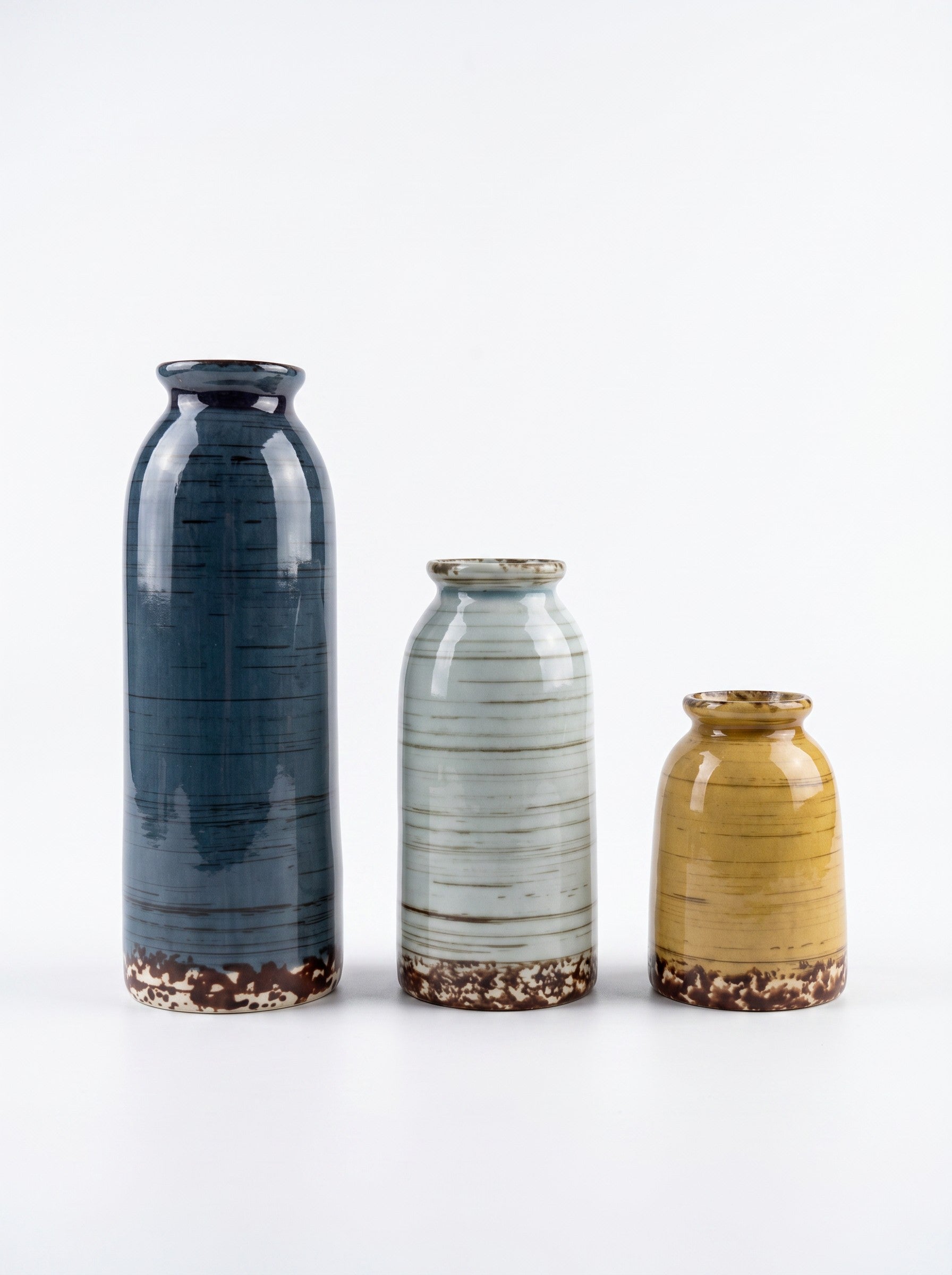 High Objects set of 3 ceramic vases in blue, yellow, and light blue with textured horizontal lines and brown speckled bases.