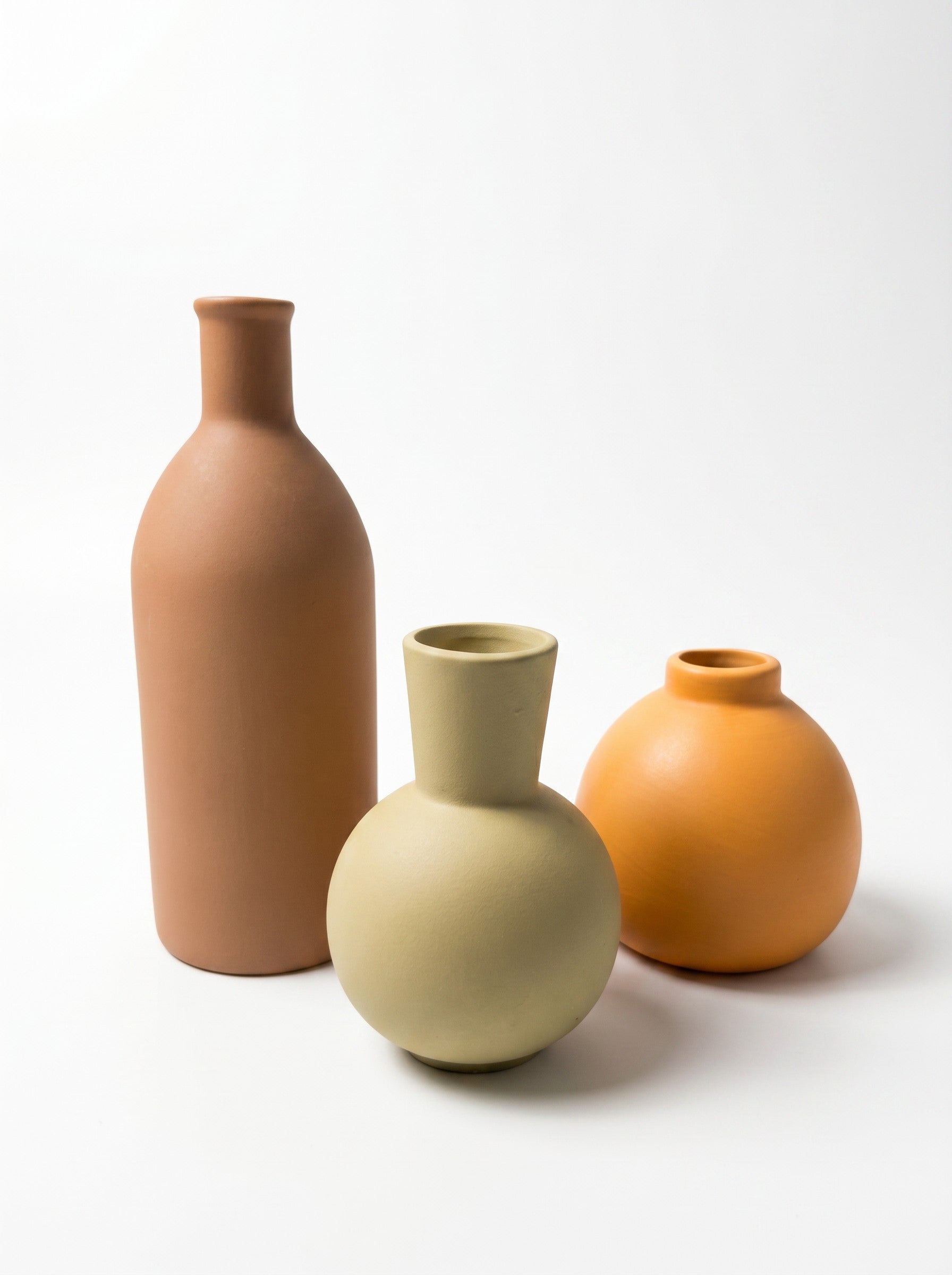 High Objects set of 3 ceramic vases in terracotta, sage green, and orange. Round and bottle shapes.