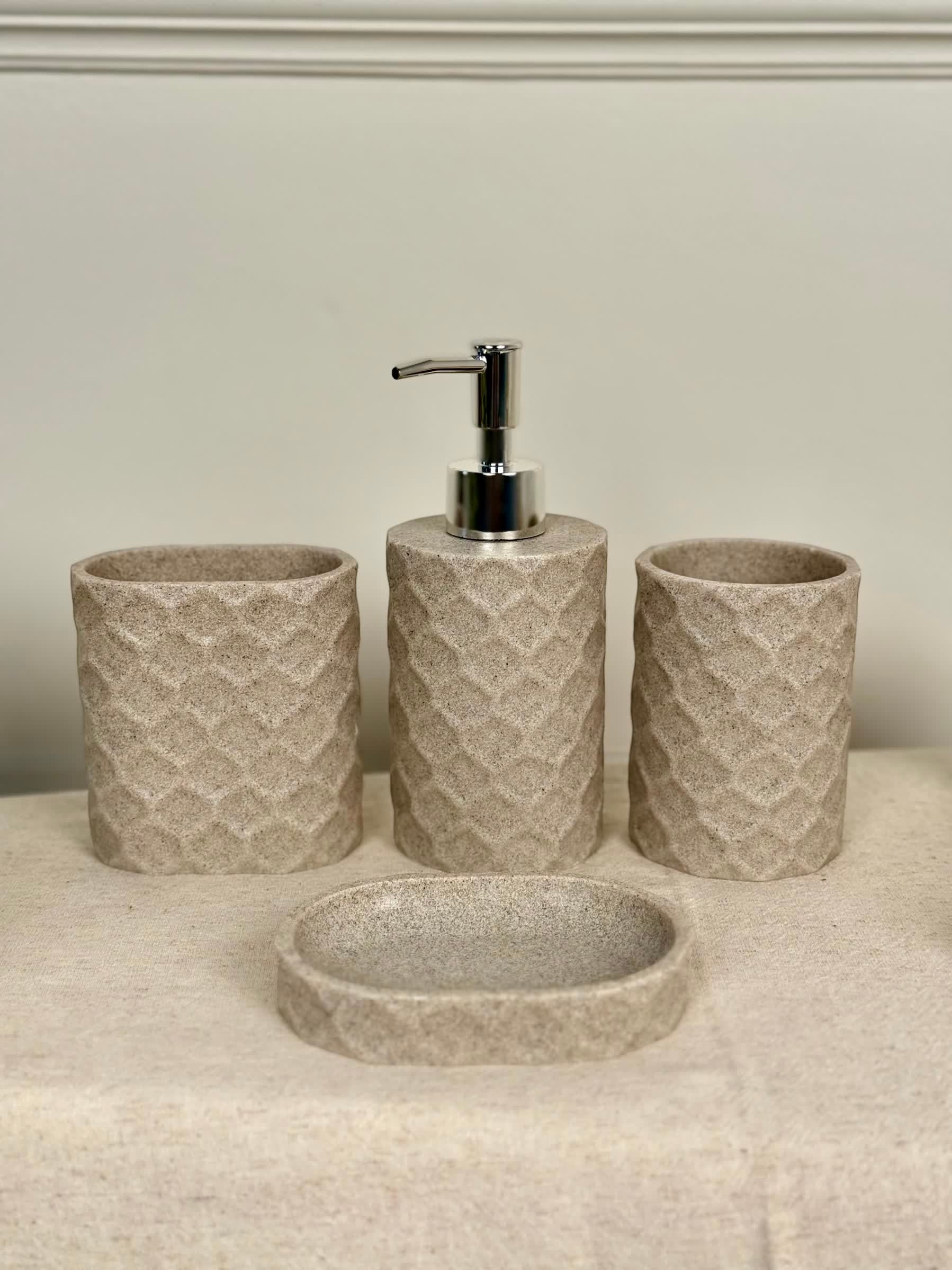 High Objects Dunecraft Bathroom Accessory Set in beige stone texture with geometric pattern. Includes soap dispenser, toothbrush holder, cup, and soap dish.
