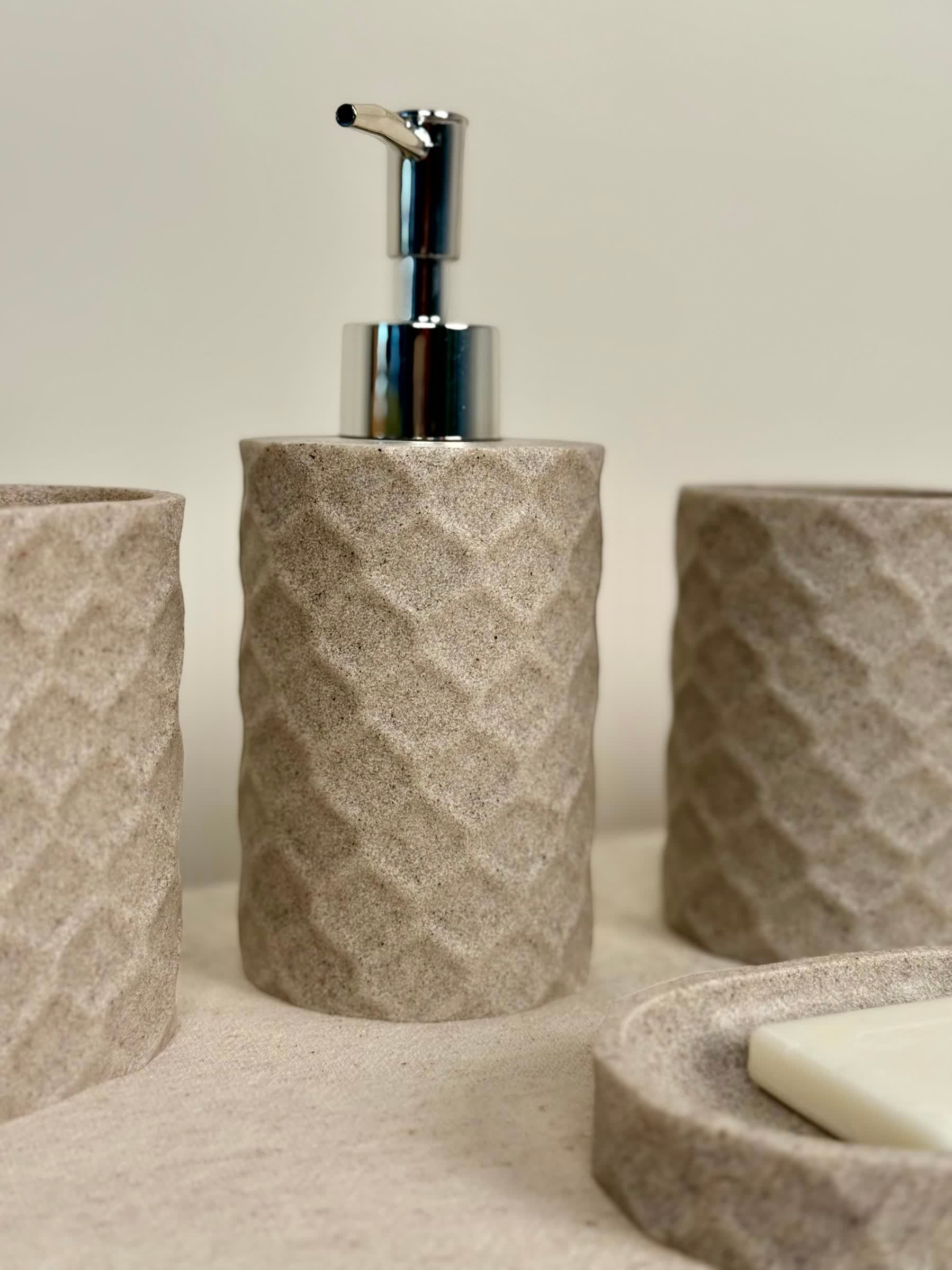 High Objects Dunecraft Bathroom Accessory Set in textured stone-like material with geometric pattern. Includes soap dispenser, cups, and soap dish.