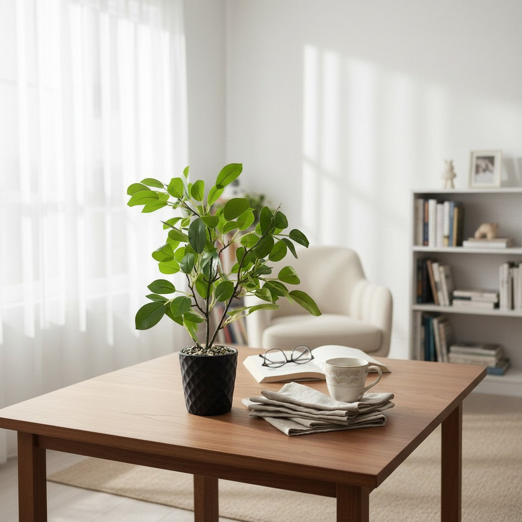 High Objects faux ficus plant in a black geometric pot with green leaves, on a wooden table with a book and glasses.