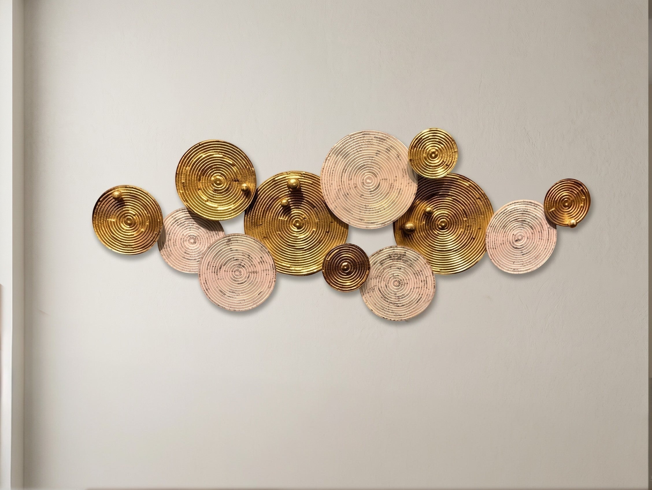 High Objects modern wall art featuring a cluster of metallic gold and textured beige circular discs on a wall.