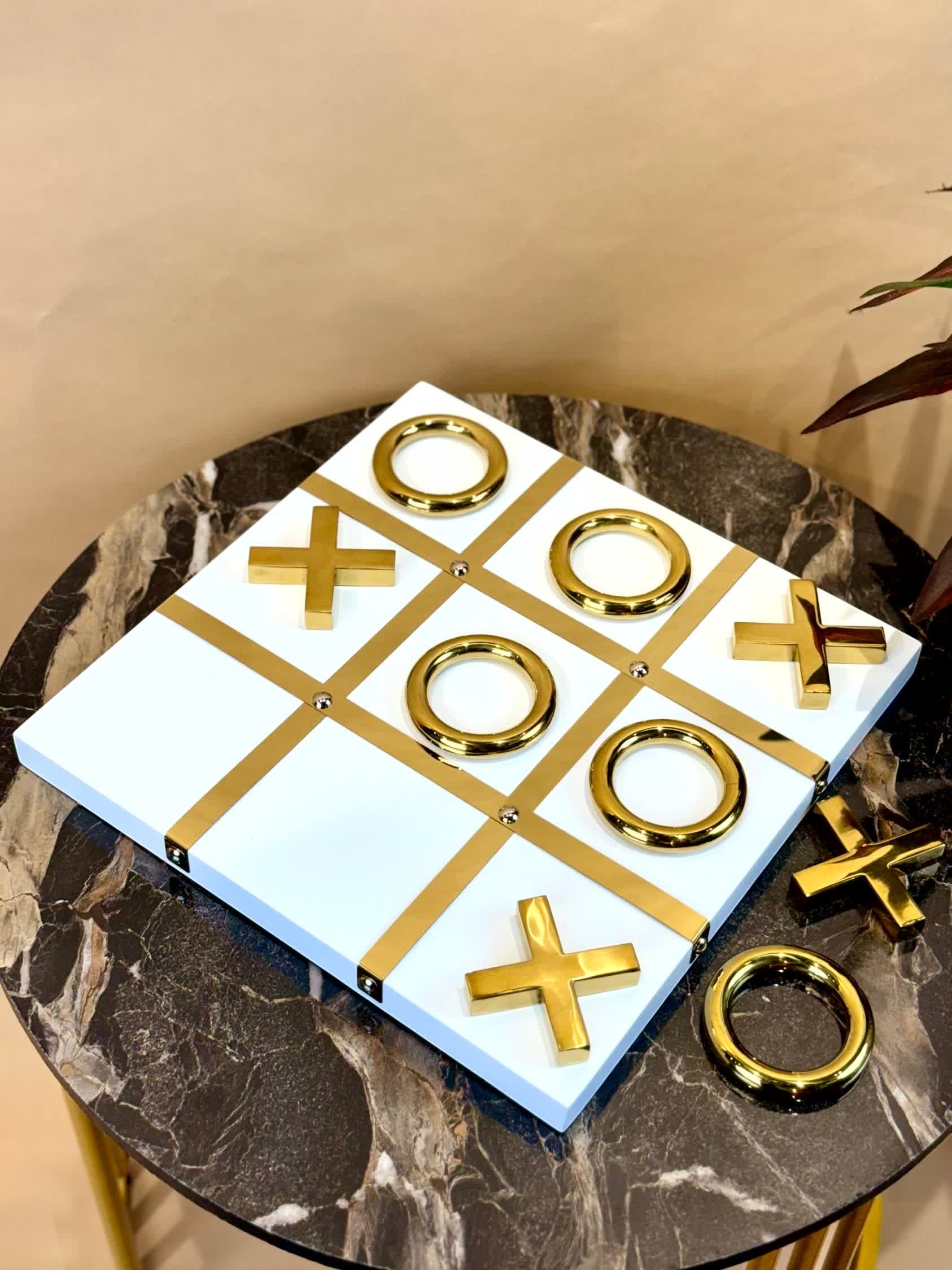 High Objects Gold Tic-Tac-Toe Set with white board and gold-tone iron pieces. Modern luxury decor.