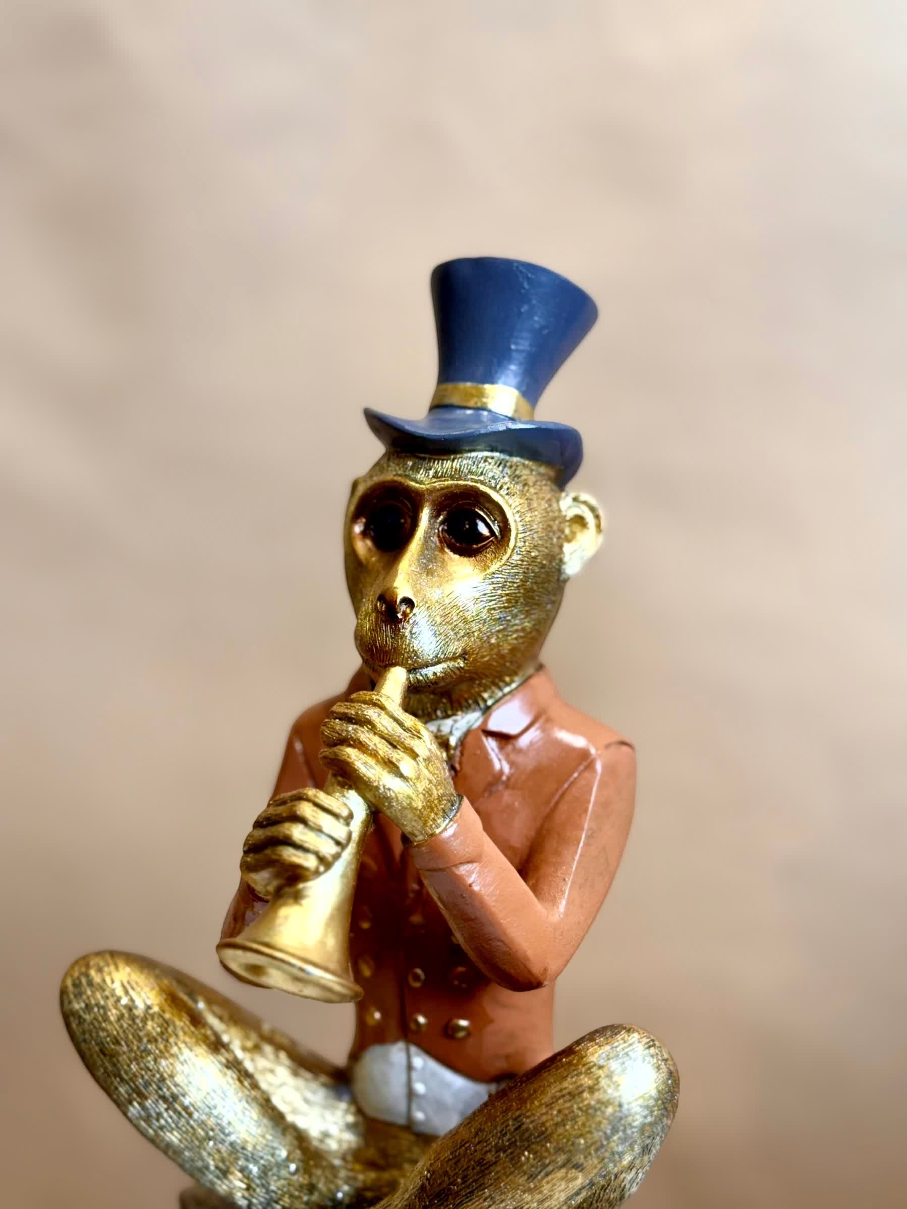 High Objects Golden Serenade Monkey Showpiece, gold monkey in vintage coat and blue top hat playing flute, polyresin.