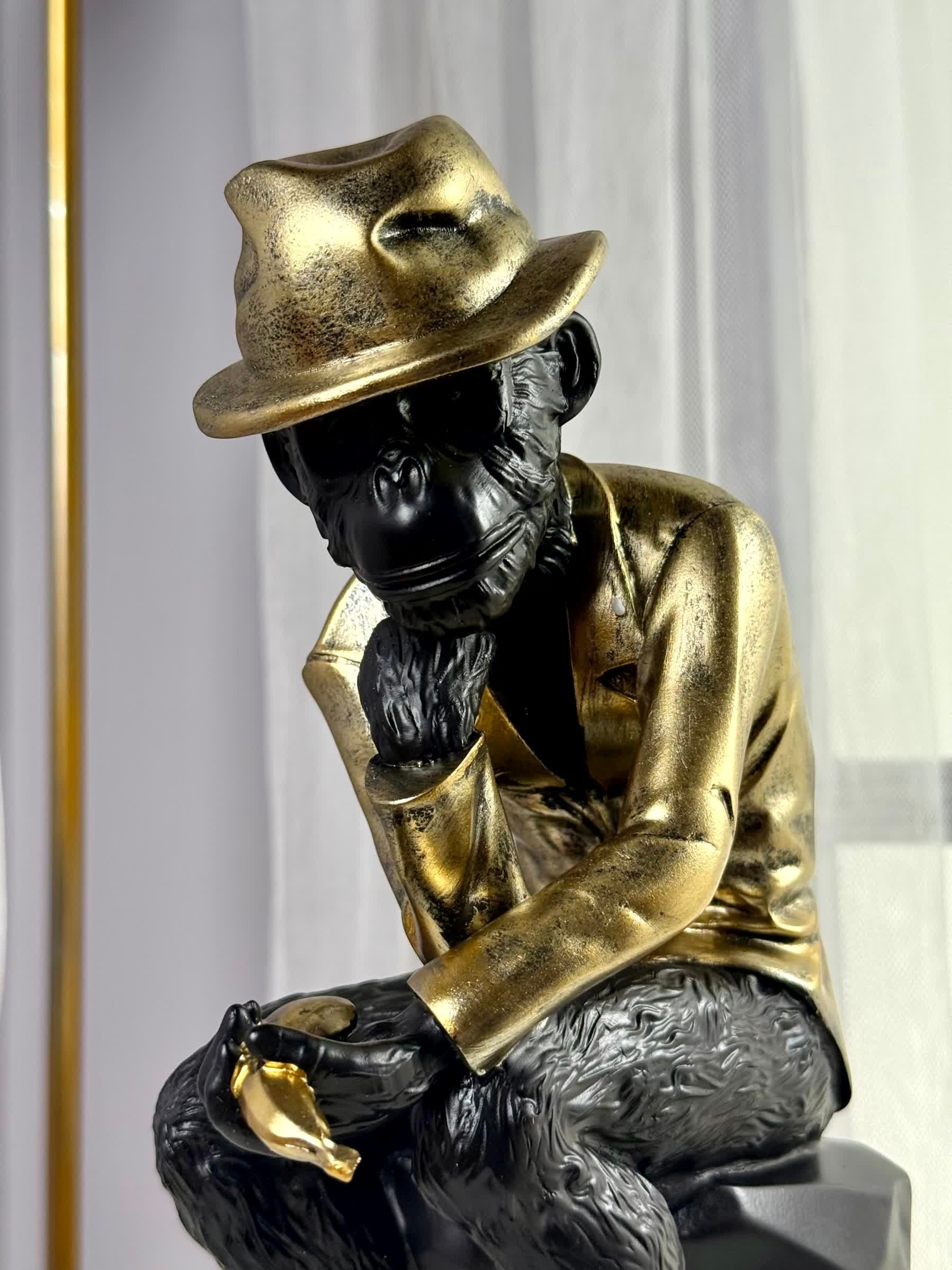 High Objects Golden Thinker Showpiece, a black polyresin monkey in a metallic gold suit and fedora, in a thoughtful pose.