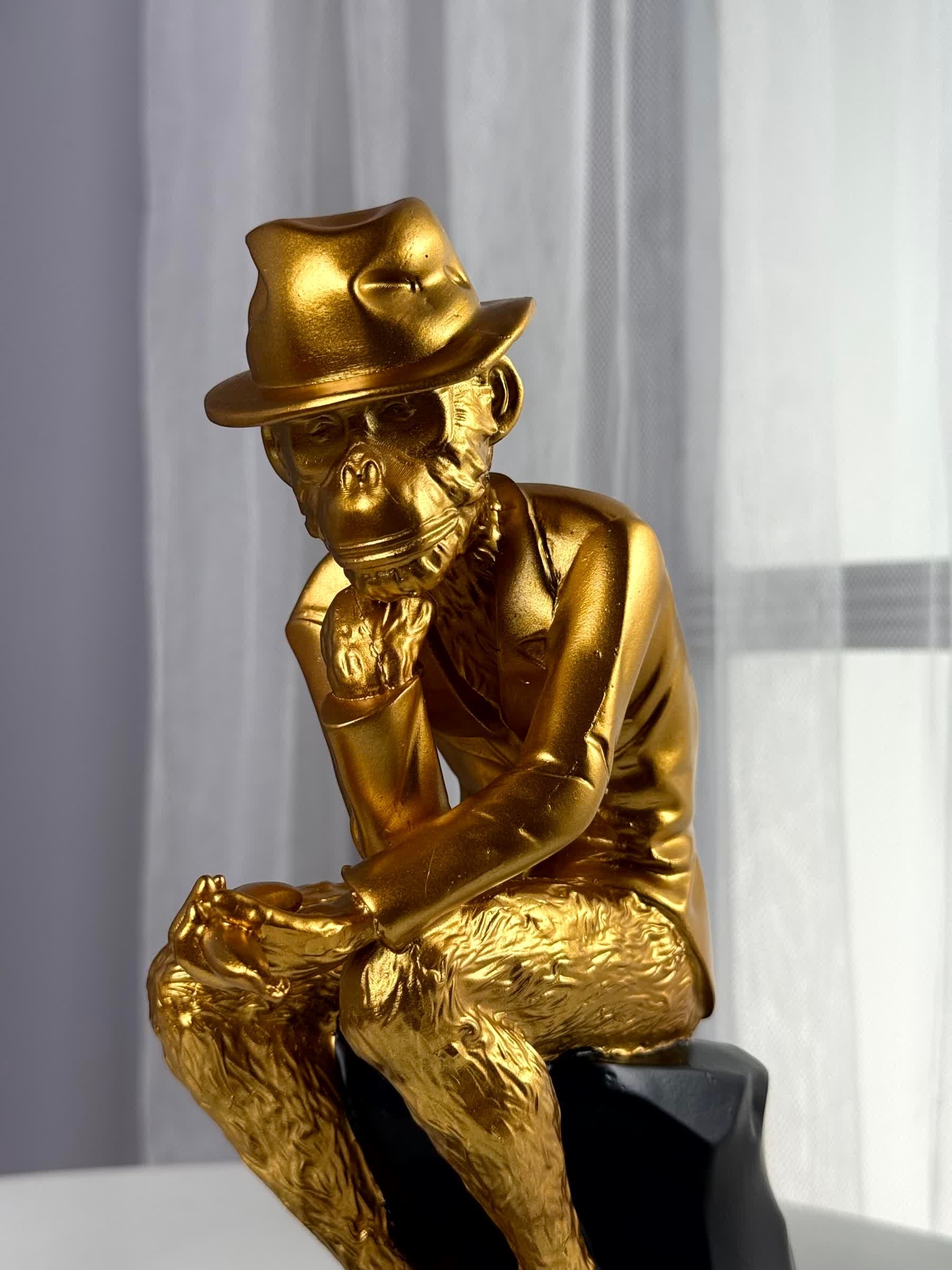 High Objects Golden Thinker Showpiece, a gold polyresin monkey figurine in a thoughtful pose wearing a fedora and suit, on a black base.