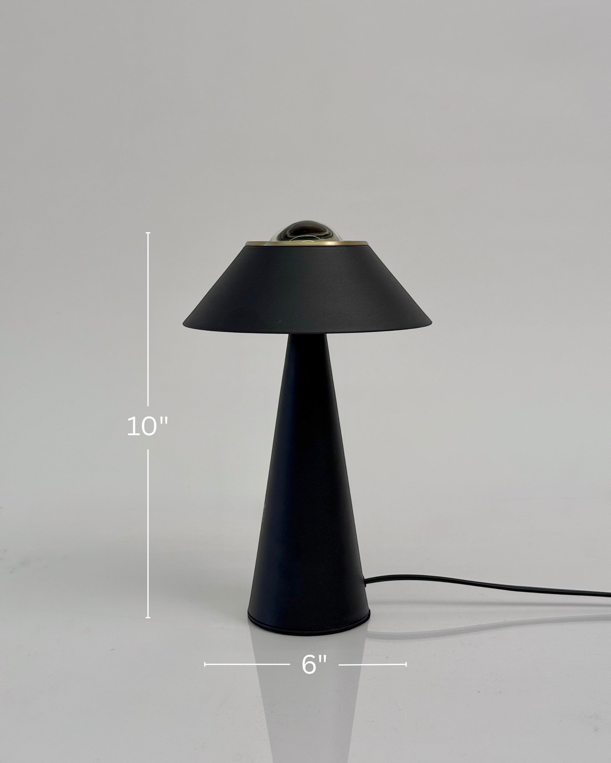 High Objects Halo Noir Table Lamp, matte black conical base with flared shade and gold accent, modern minimalist design.