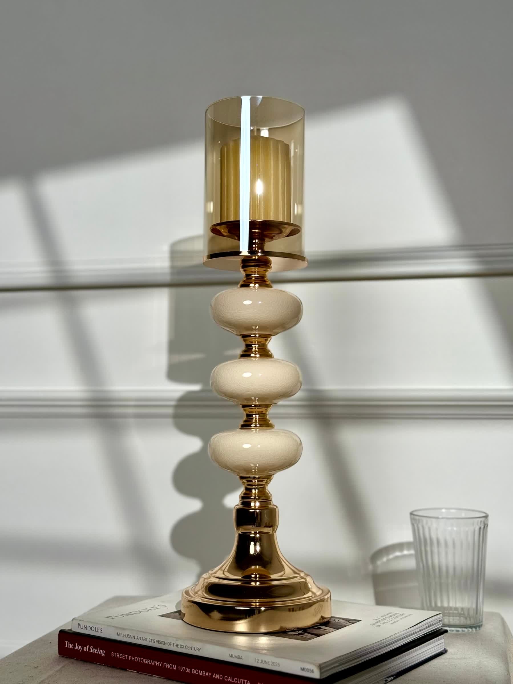 High Objects Opaline Gold Candle Stand Collection with amber glass hurricane shade and stacked opaline accents.