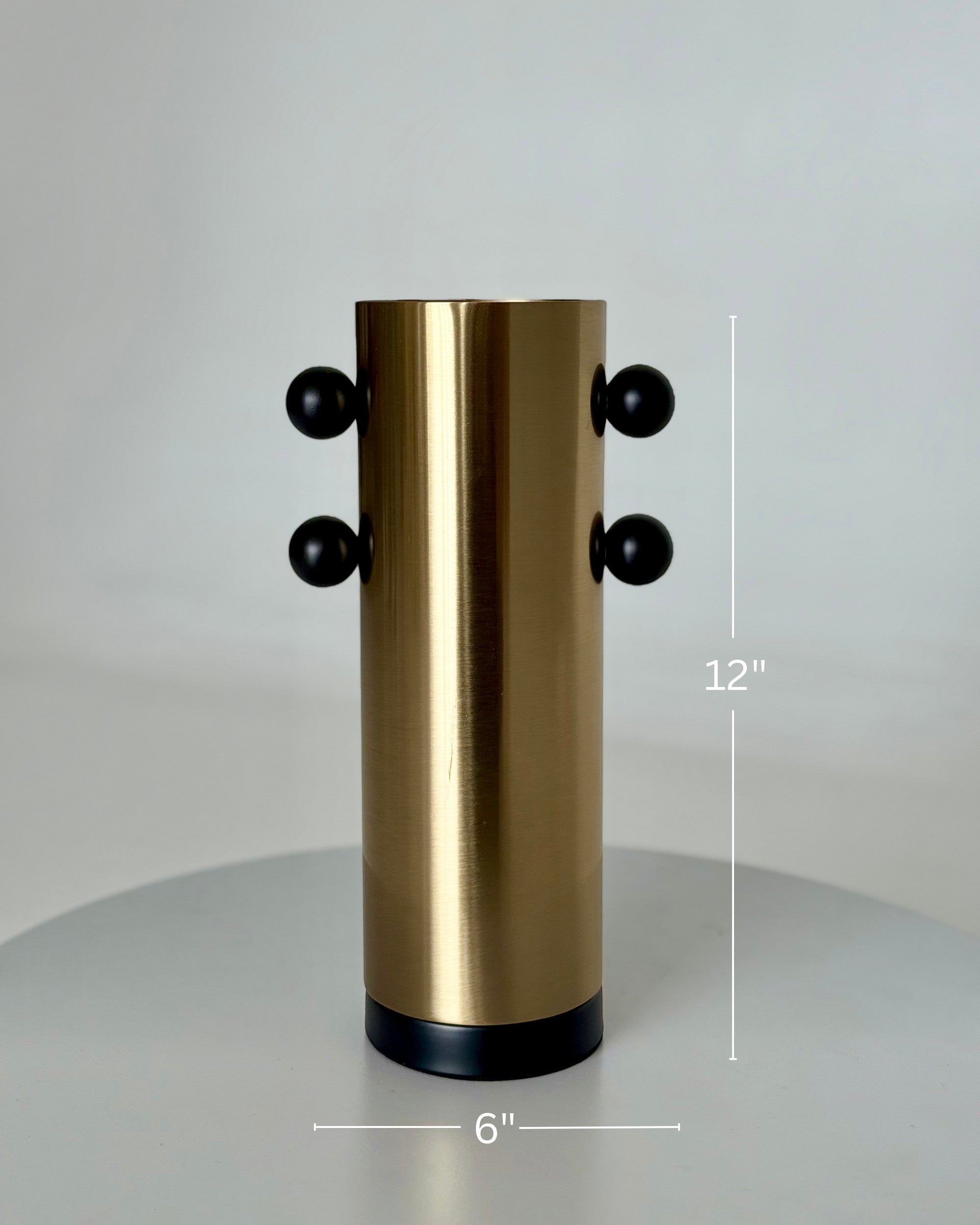 High Objects Orbis Luxe Vase: Cylindrical gold vase with black orb accents, 12" H x 6" W.