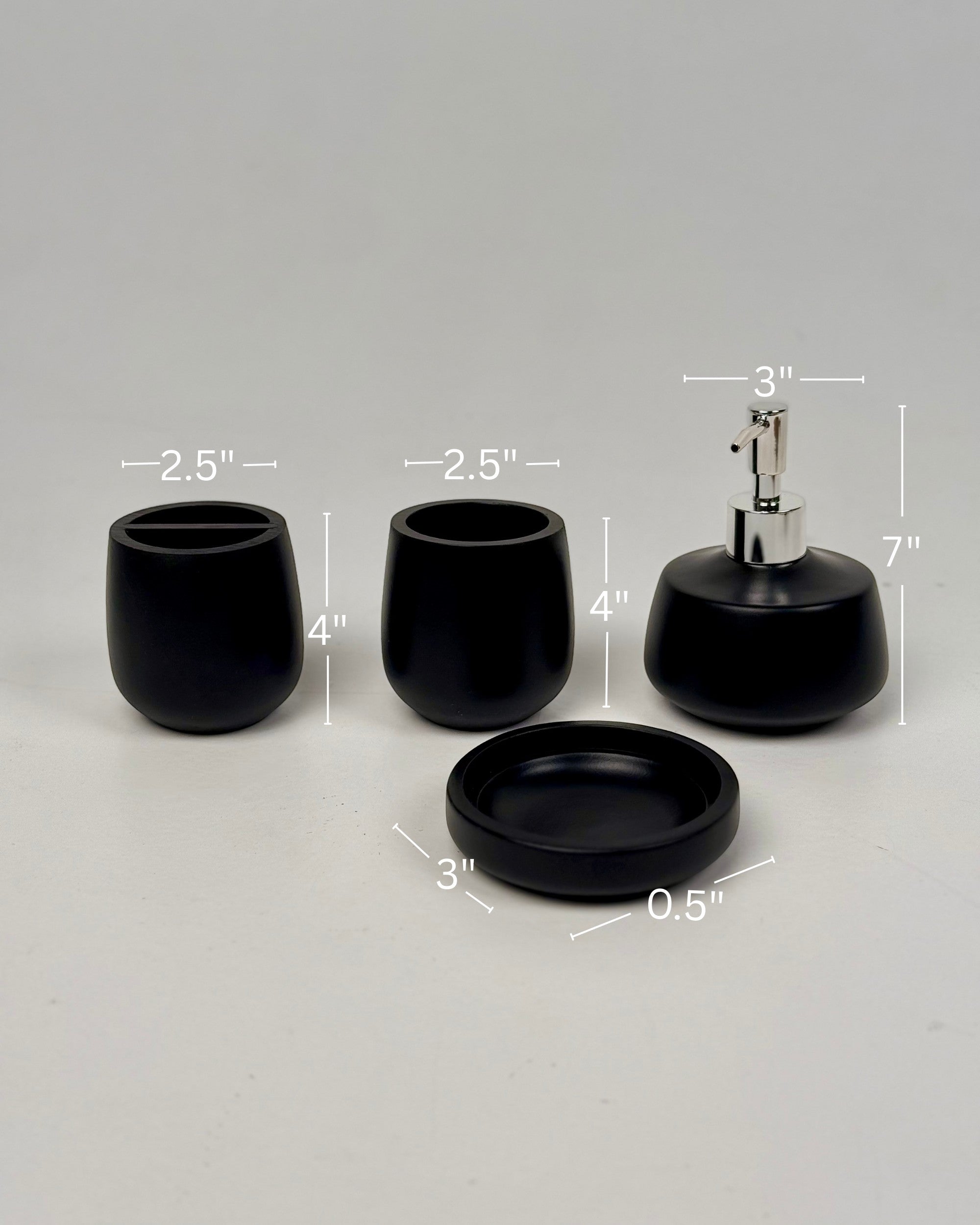 High Objects Pebbleease black bathroom accessory set with soap dispenser, toothbrush holder, and dish. Smooth, organic shapes.
