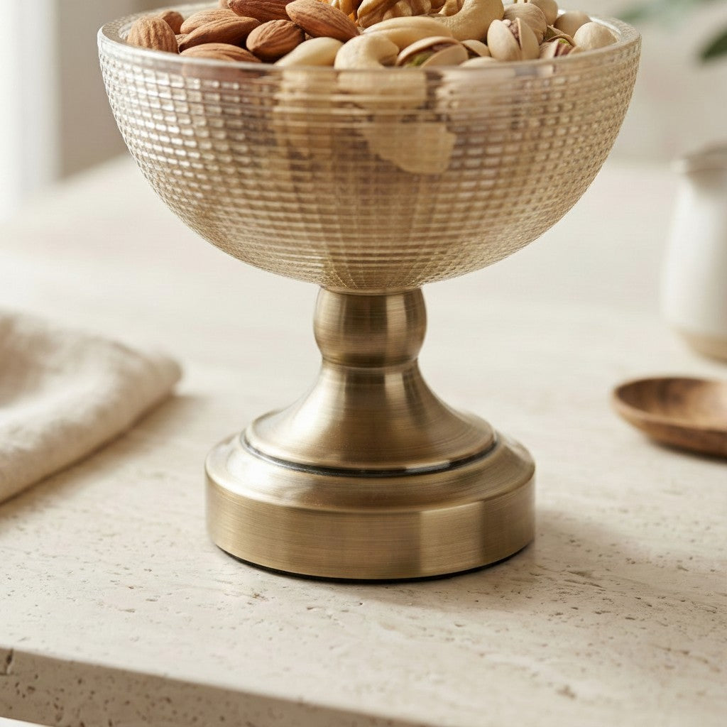 High Objects antique brass pedestal bowl with textured glass, filled with mixed nuts.