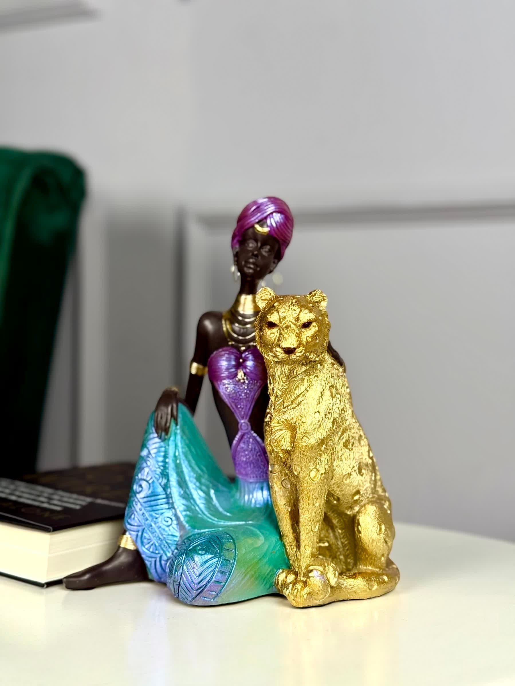 High Objects Queen of the Wild showpiece: African woman in jewel-toned attire with gold leopard. Polyresin.