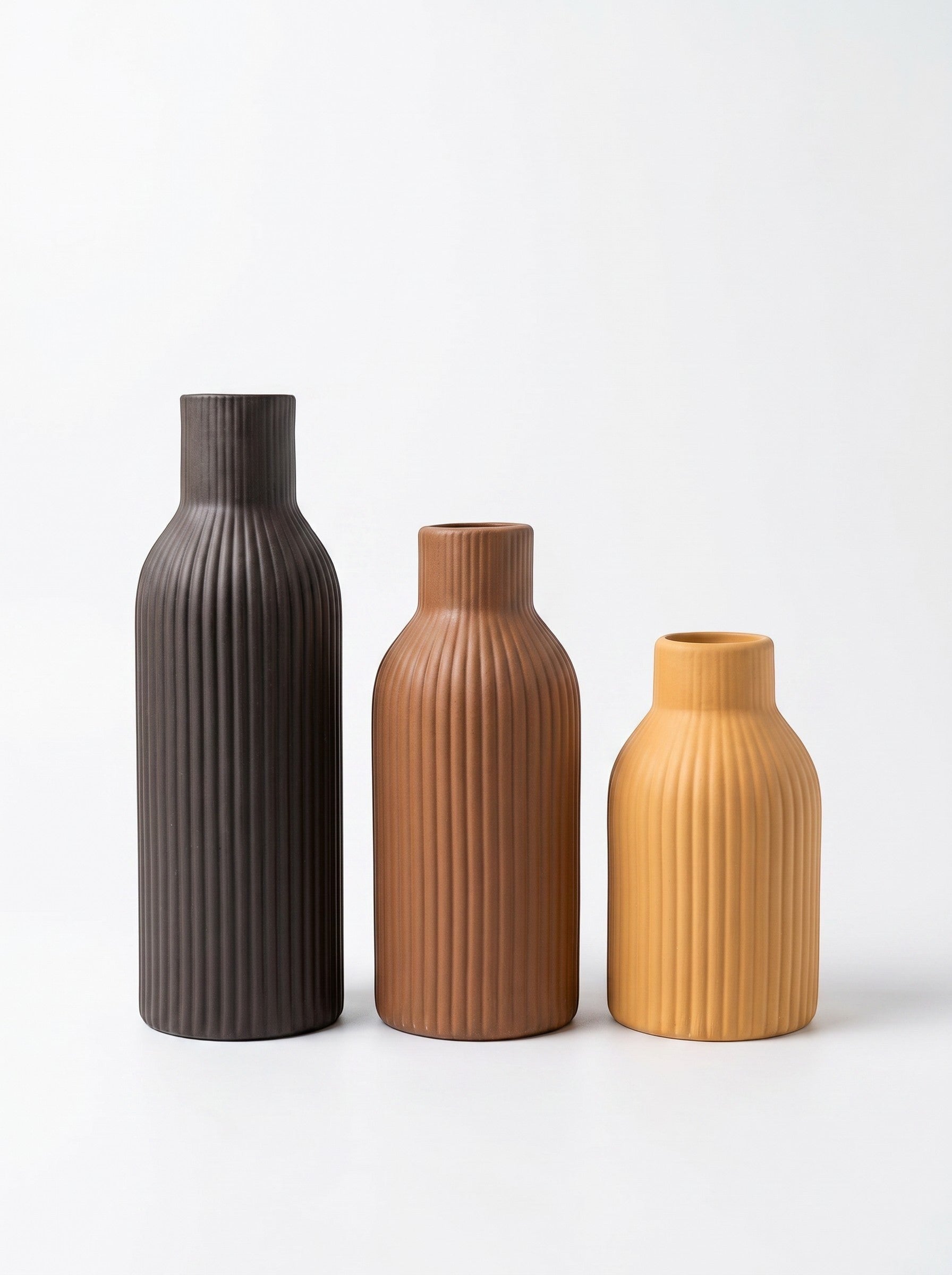 High Objects set of 3 ribbed ceramic vases in black, mustard yellow, and brown.