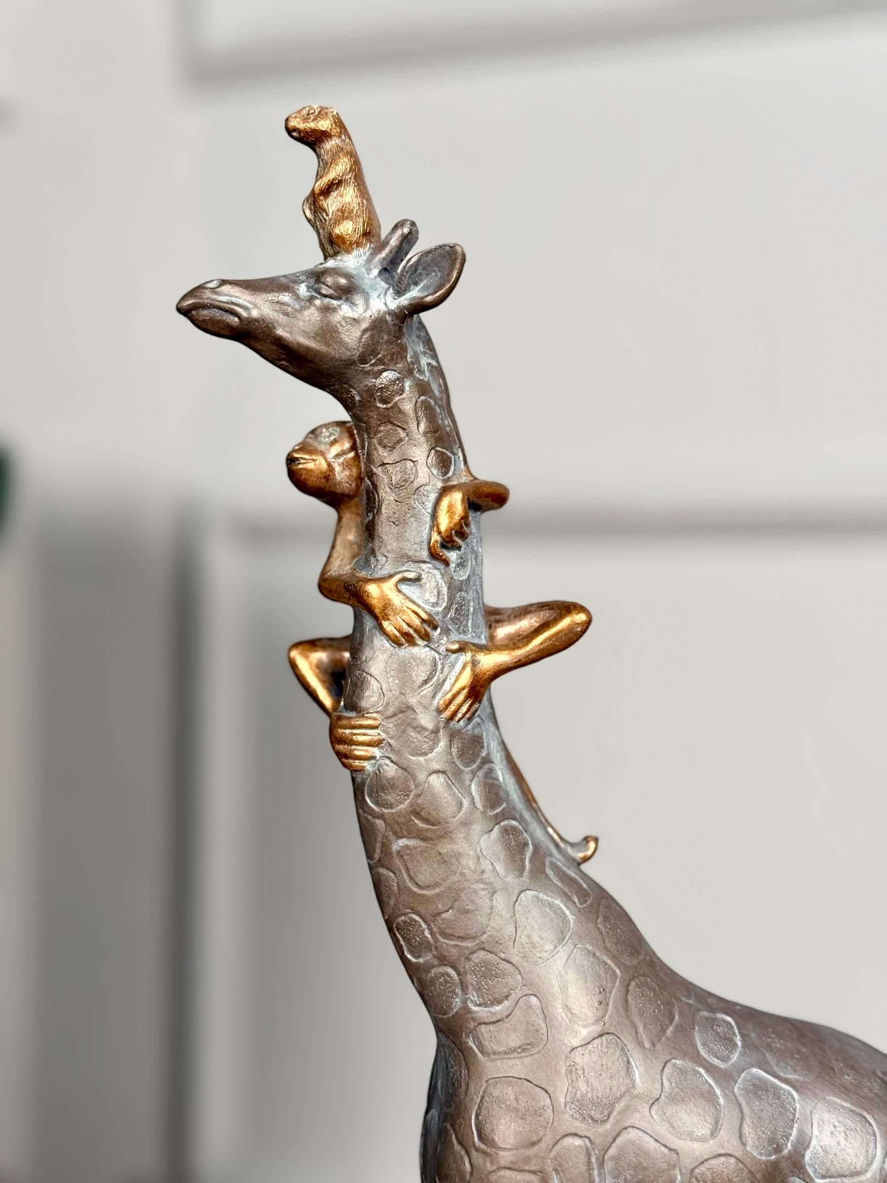 High Objects Savannah Majesty Showpiece sculpture of a giraffe with two monkeys climbing its neck, dark polyresin with textured patterns.