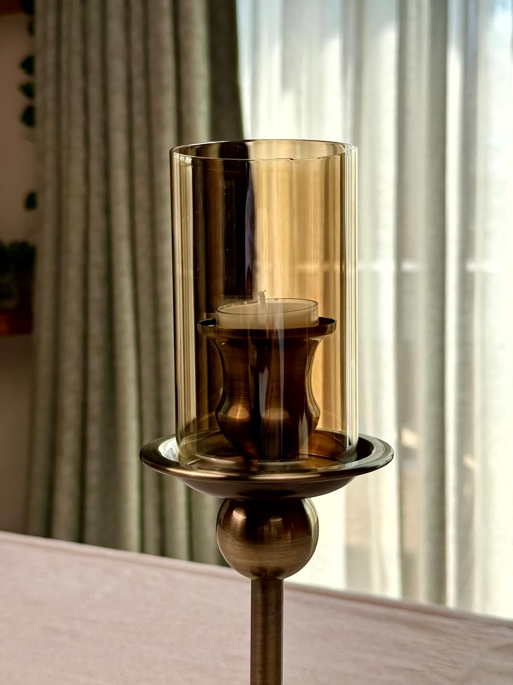 High Objects Seren Column Candle Stand Set with amber glass hurricane and metallic base. Bronze finish.
