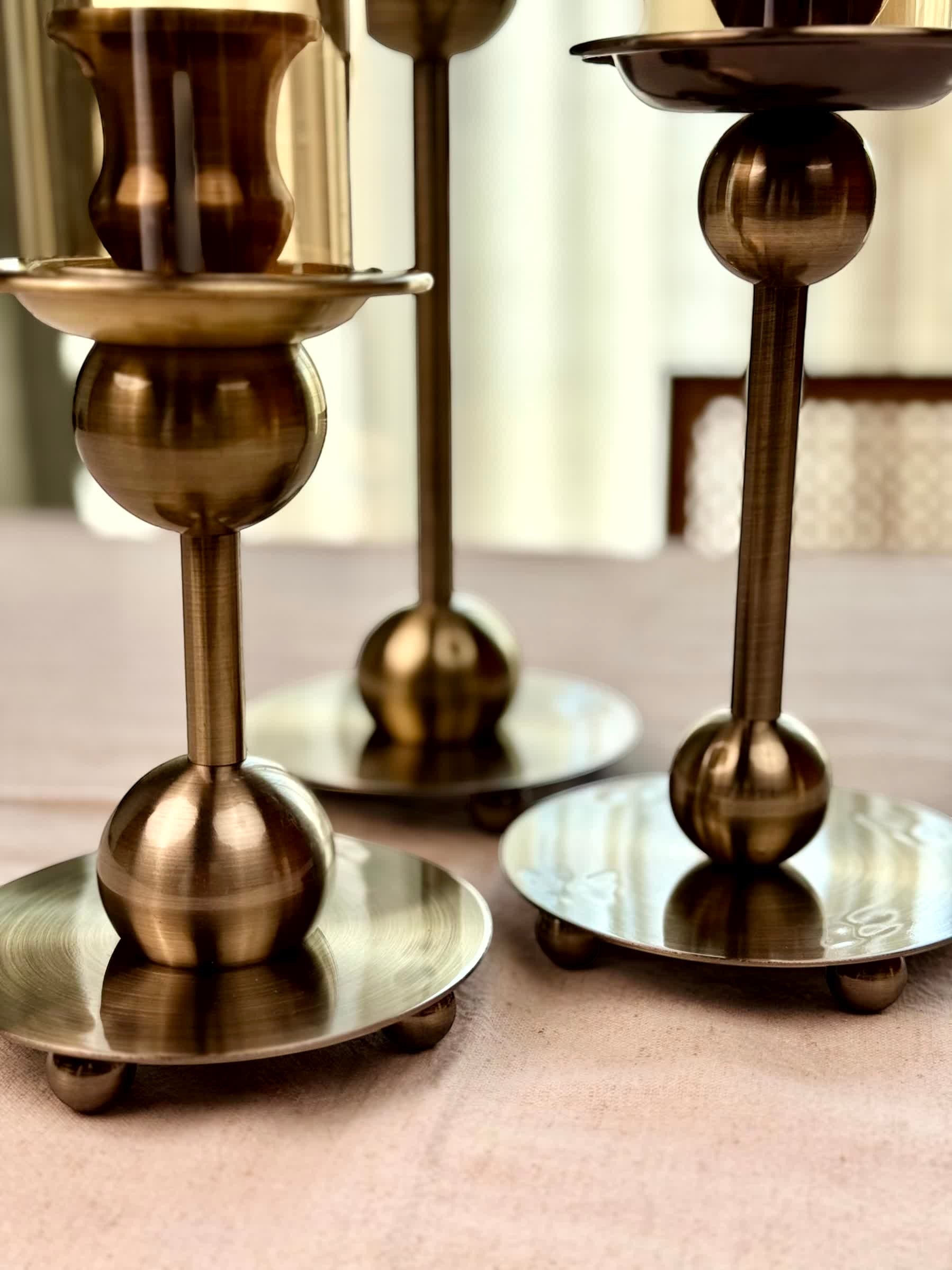 High Objects Seren Column Candle Stand Set in antique brass finish with sphere detail and wide base. Set of 2.