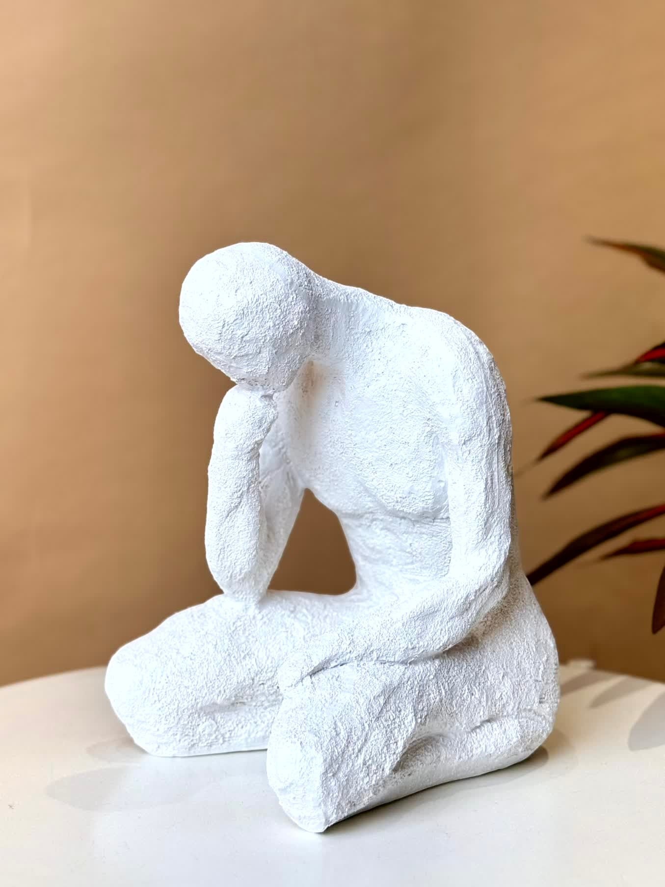 High Objects textured white polyresin showpiece of a faceless figure in a contemplative pose, 10 inches tall.