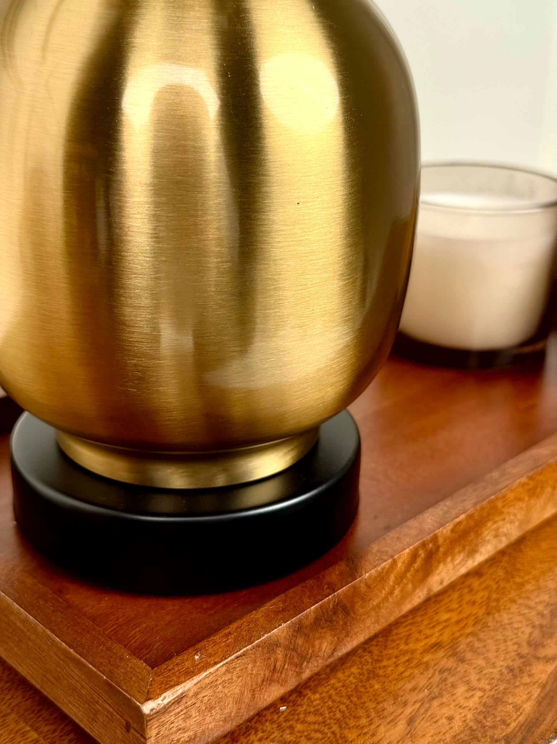 High Objects Solara Sculpted Vase in brushed gold metal with a black base, featuring a rounded body and slender neck.