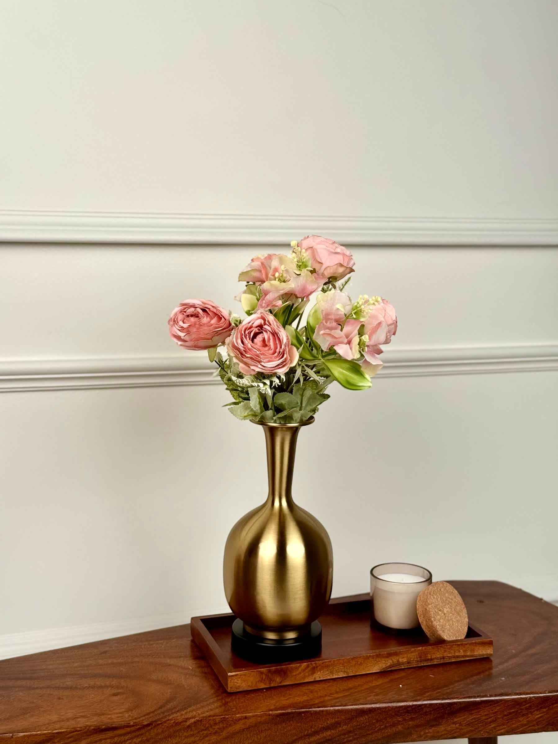 High Objects Solara Sculpted Vase in brushed gold metal with a rounded body and slender neck, holding pink floral arrangement.