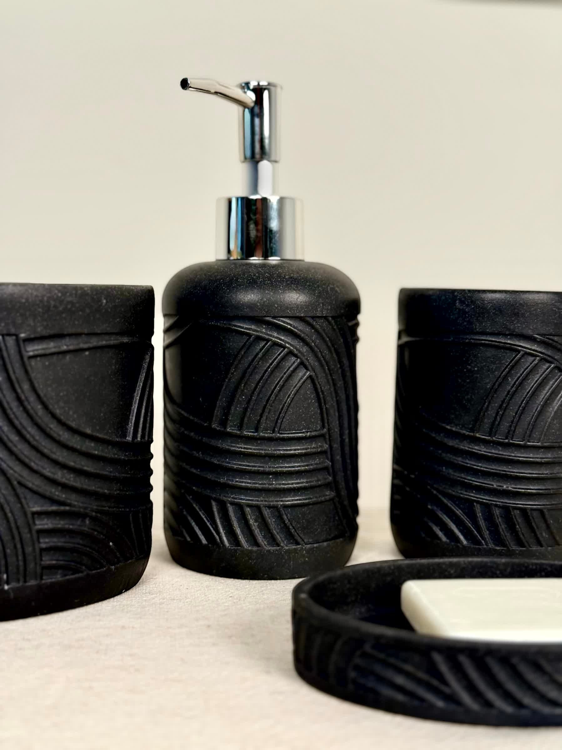 High Objects Stratacurve black bathroom accessory set with carved curved groove detailing. Includes soap dispenser, tumbler, and soap dish.