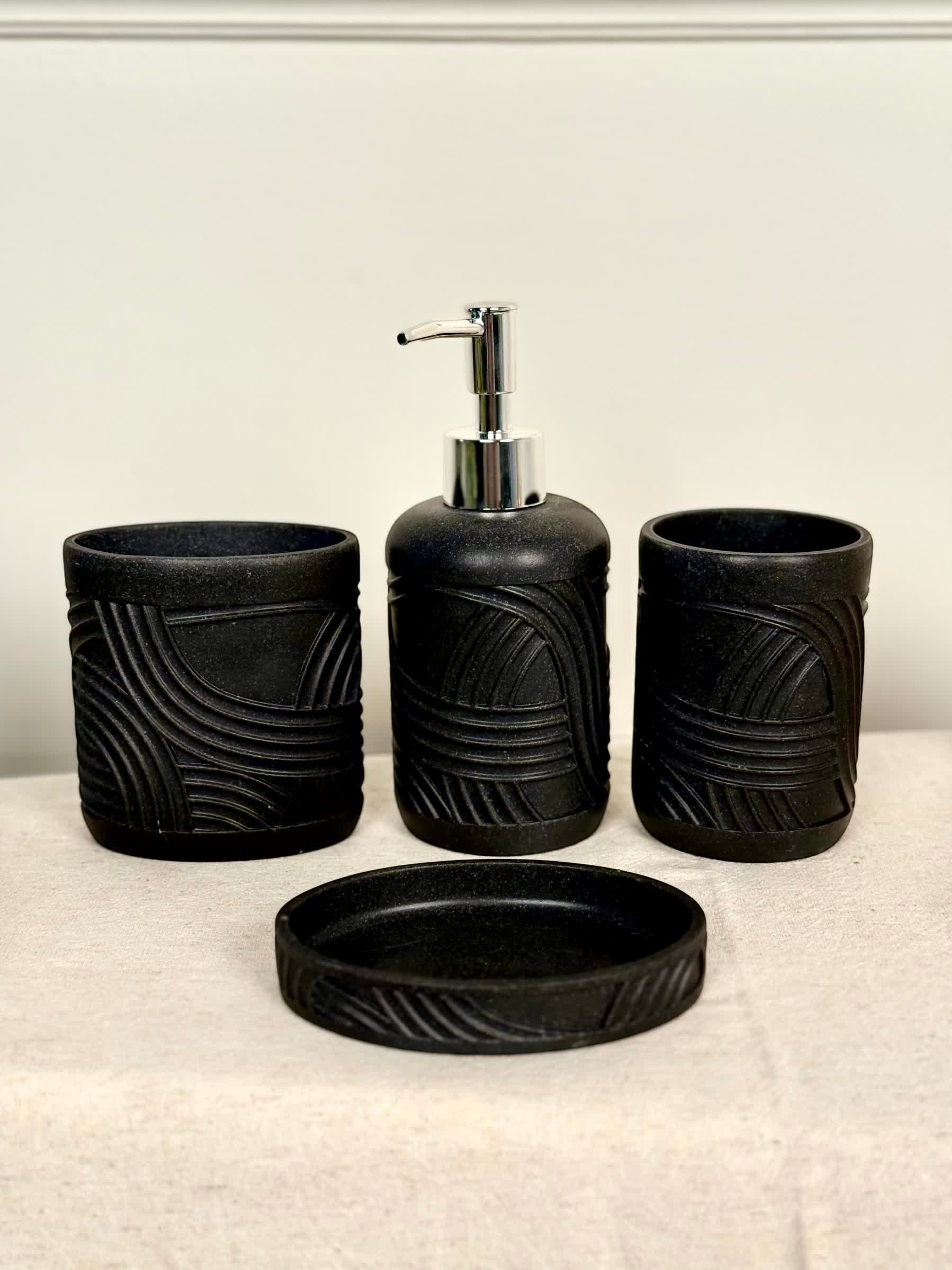 High Objects Stratacurve black bathroom accessory set with carved groove detailing. Includes soap dispenser, two cups, and soap dish.
