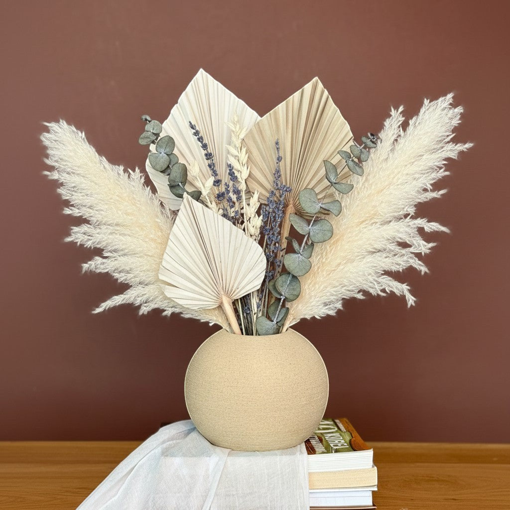 High Objects spherical ceramic vase in beige with dried pampas grass, palm leaves, eucalyptus, and lavender.