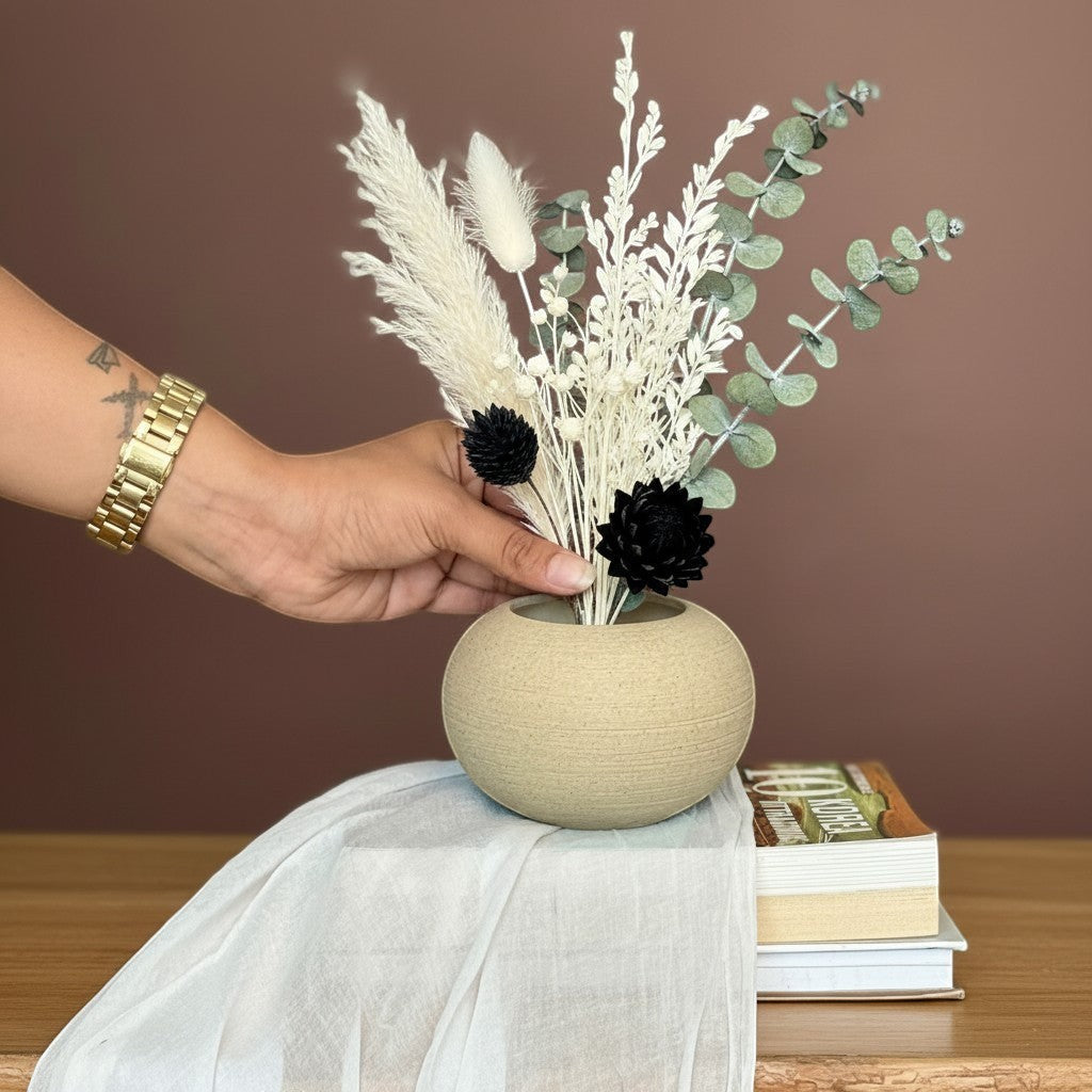 High Objects TerraSphere Ceramic Vase, a beige spherical vase with an earthy texture, holding dried flowers and eucalyptus.