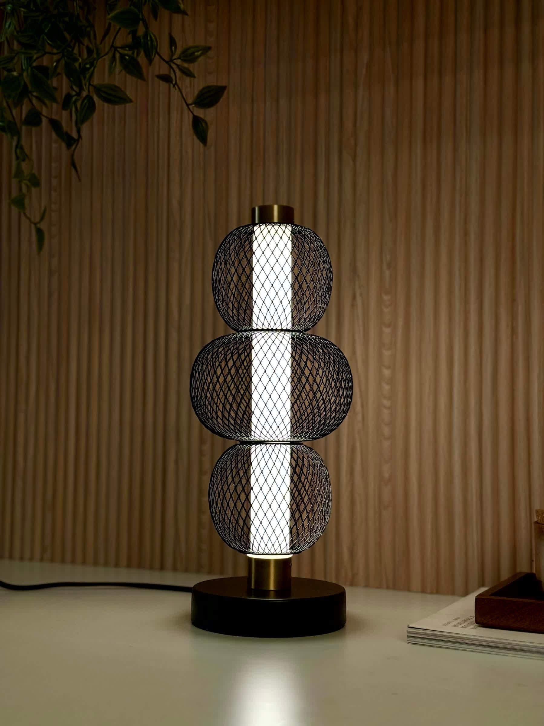 High Objects Trinity Slim Mesh Table Lamp with stacked black mesh spheres, brushed gold accents, and matte black base.
