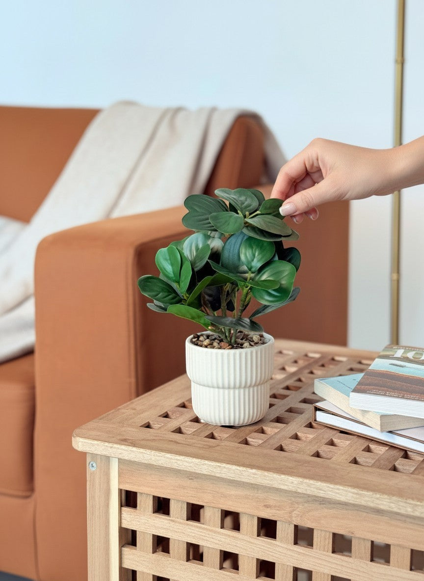 High Objects white ribbed ceramic vase with artificial ficus plant and pebbles on a wooden table.