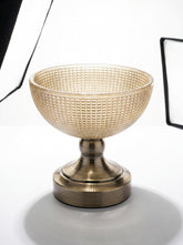 High Objects textured amber glass bowl with a brass pedestal base, perfect for decorative use.