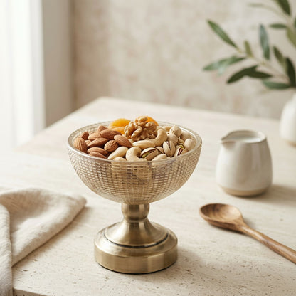 High Objects antique brass textured pedestal bowl filled with almonds, cashews, pistachios, walnuts, and dried apricots.