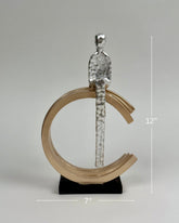 High Objects Arc of Solitude showpiece: metallic figure seated on gold arc, black base. Modern polyresin decor.