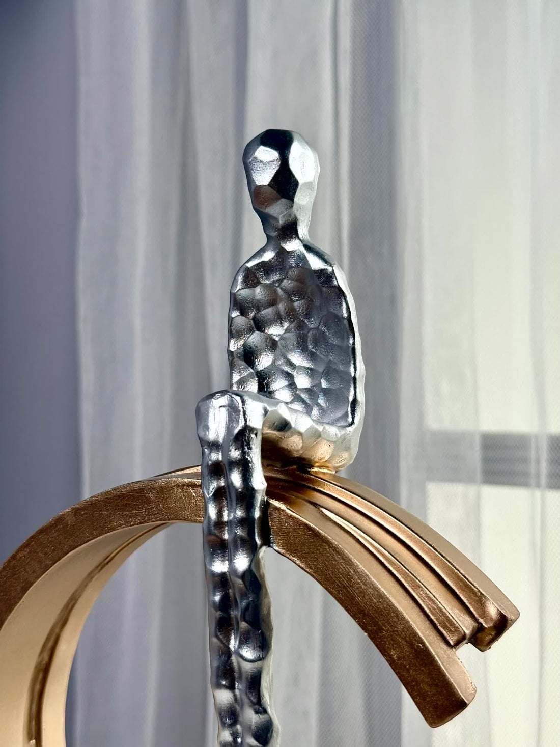 High Objects Arc of Solitude showpiece, silver figure seated on a gold arc, polyresin with metallic finish.