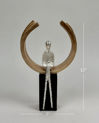 High Objects Arc of Reflection Showpiece, silver hammered figure seated on black base within gold arc. Modern sculpture.