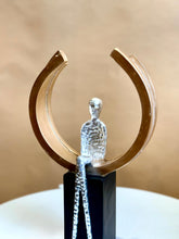 High Objects Arc of Reflection Showpiece, silver hammered figure seated in gold arc on black base, modern art sculpture.