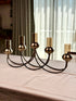 High Objects Aria Five-Arm Candle Stand in antique brass with glass holders, elegant centerpiece for dining tables.