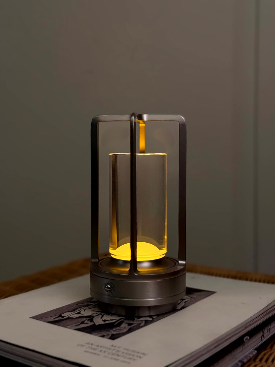 High Objects Aria Frame Table Lamp with clear glass shade and brushed metal base, emits warm yellow light.