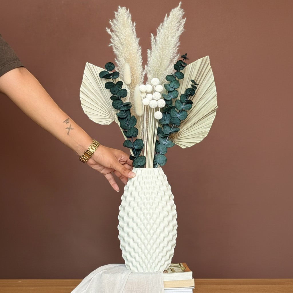 High Objects Arisca Vase, a textured ceramic vase with a wave-like pattern, holding dried pampas grass, eucalyptus, and palm leaves.