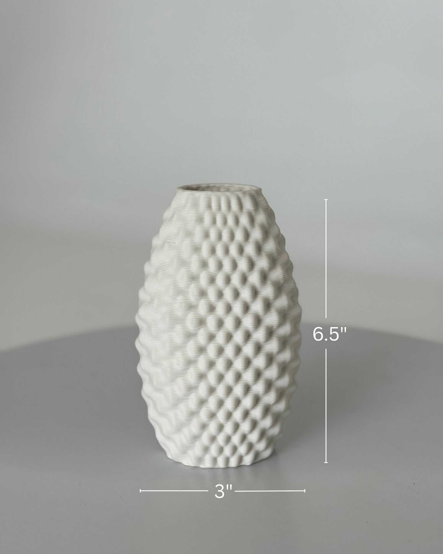 High Objects Arisca Vase, white ceramic with a textured, wave-like pattern. 6.5" H x 3" W.
