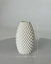 High Objects Arisca Vase, white ceramic with a textured, wave-like pattern. 6.5" H x 3" W.