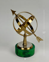 High Objects Armillary Globe Artefact with brass finish and arrow design on a green marble base.