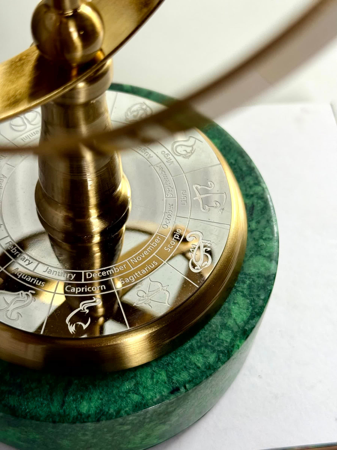 High Objects Armillary Globe Artefact with brass finish, zodiac symbols, and green marble base.