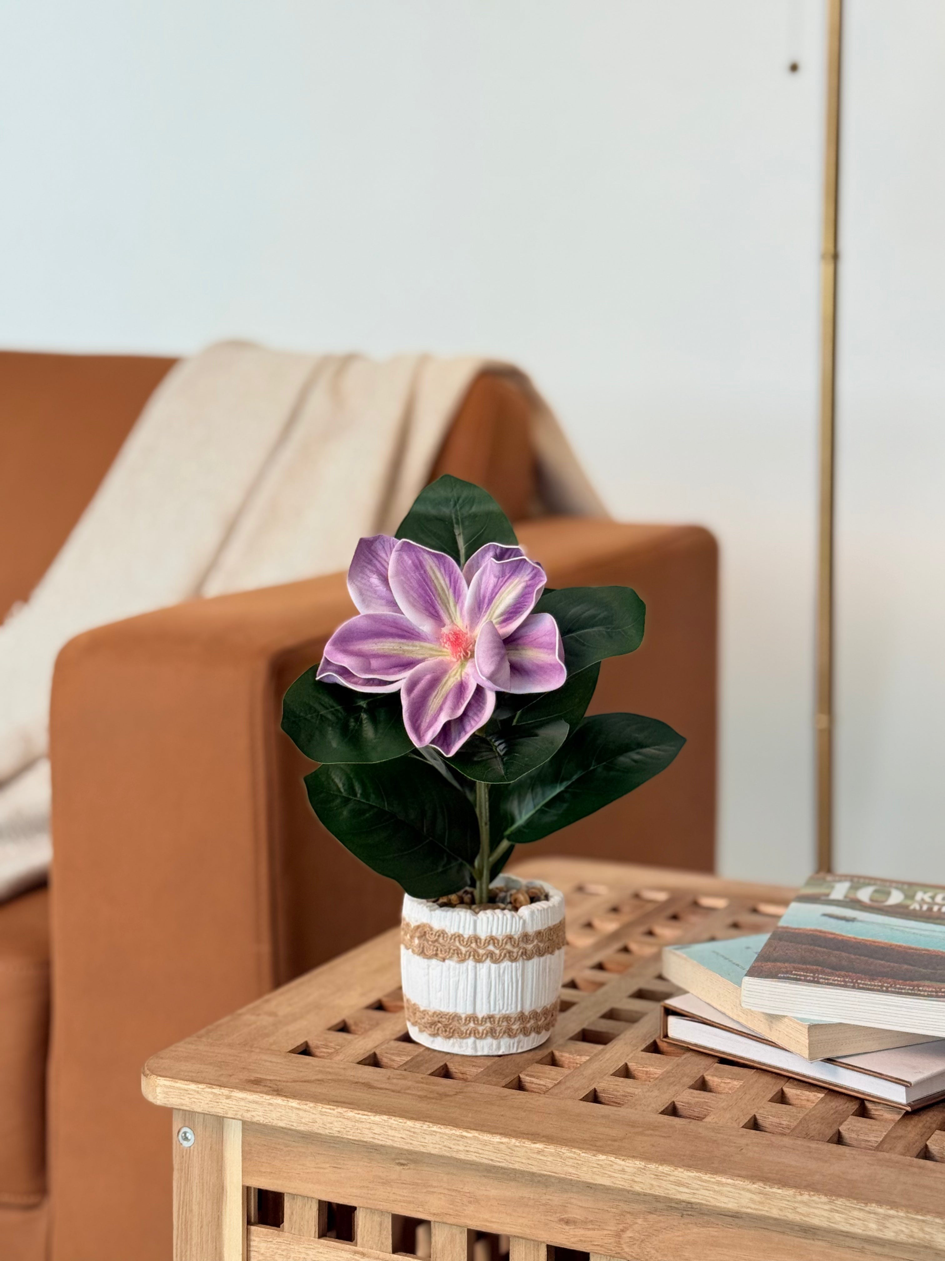 High Objects artificial purple lily plant with green leaves in a white striped ceramic pot with pebbles.