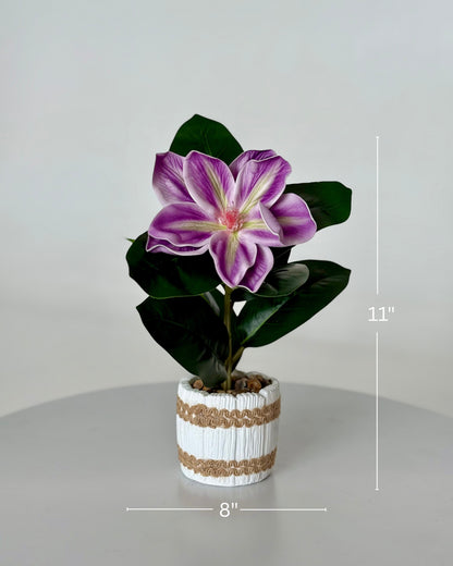High Objects artificial purple and white lily plant in a white striped ceramic pot with pebbles. 11" H x 8" W.