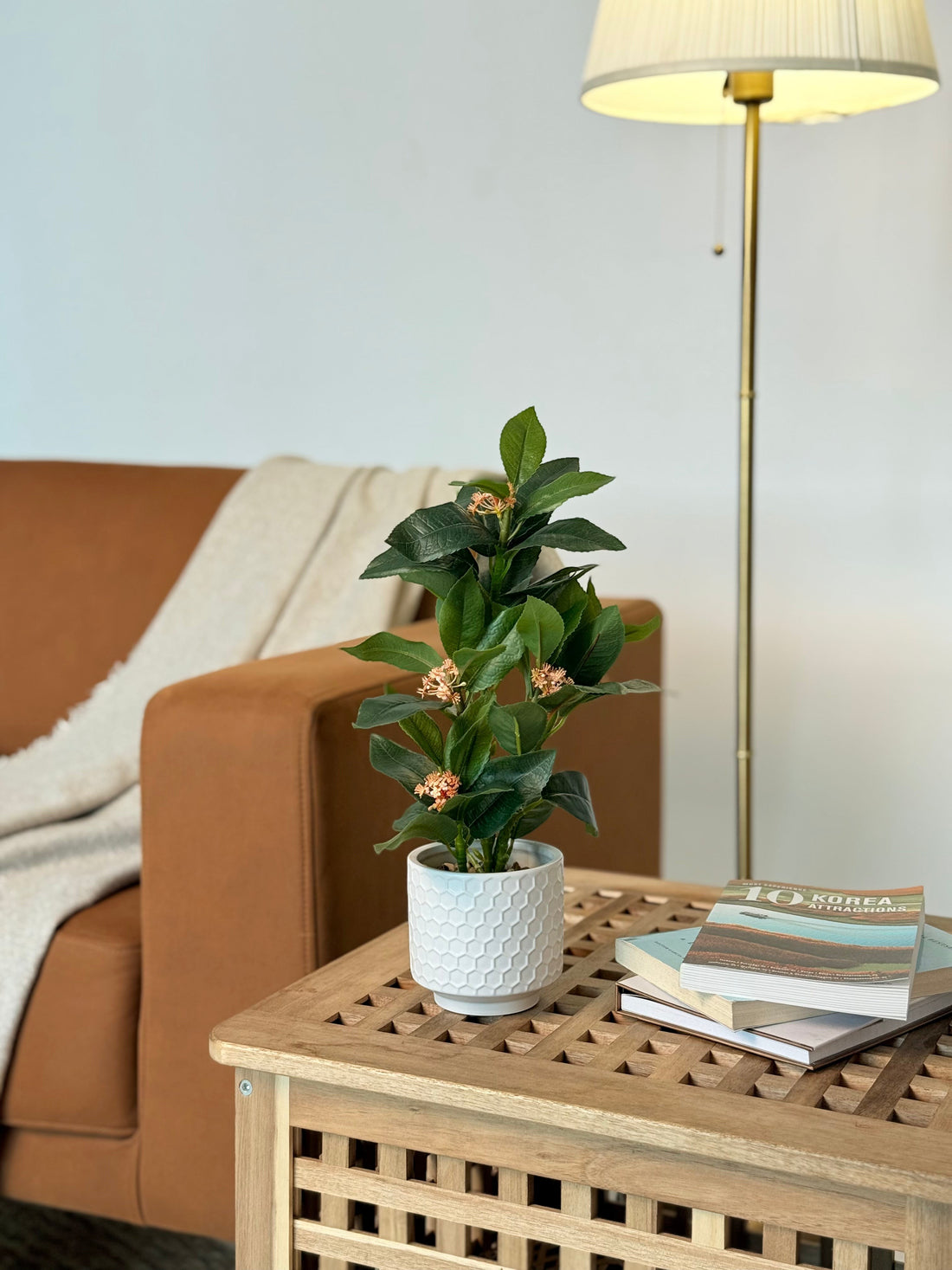 High Objects Artificial Orange Bloom Camellia Plant with green leaves in a white honeycomb pot.