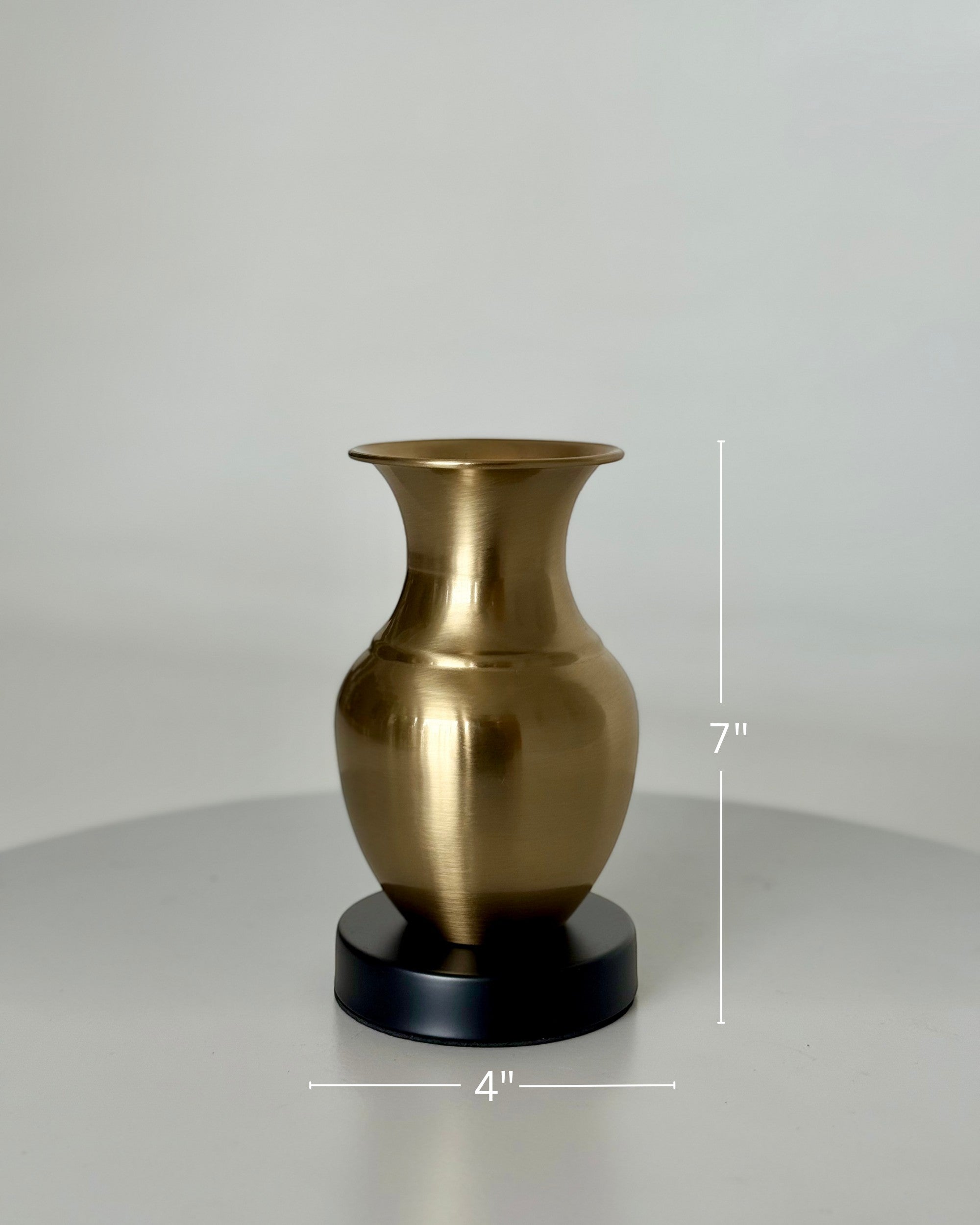 High Objects Aurelia Vase, brushed gold metallic finish, rounded body, flared neck, on a black base. 7" H x 4" W.