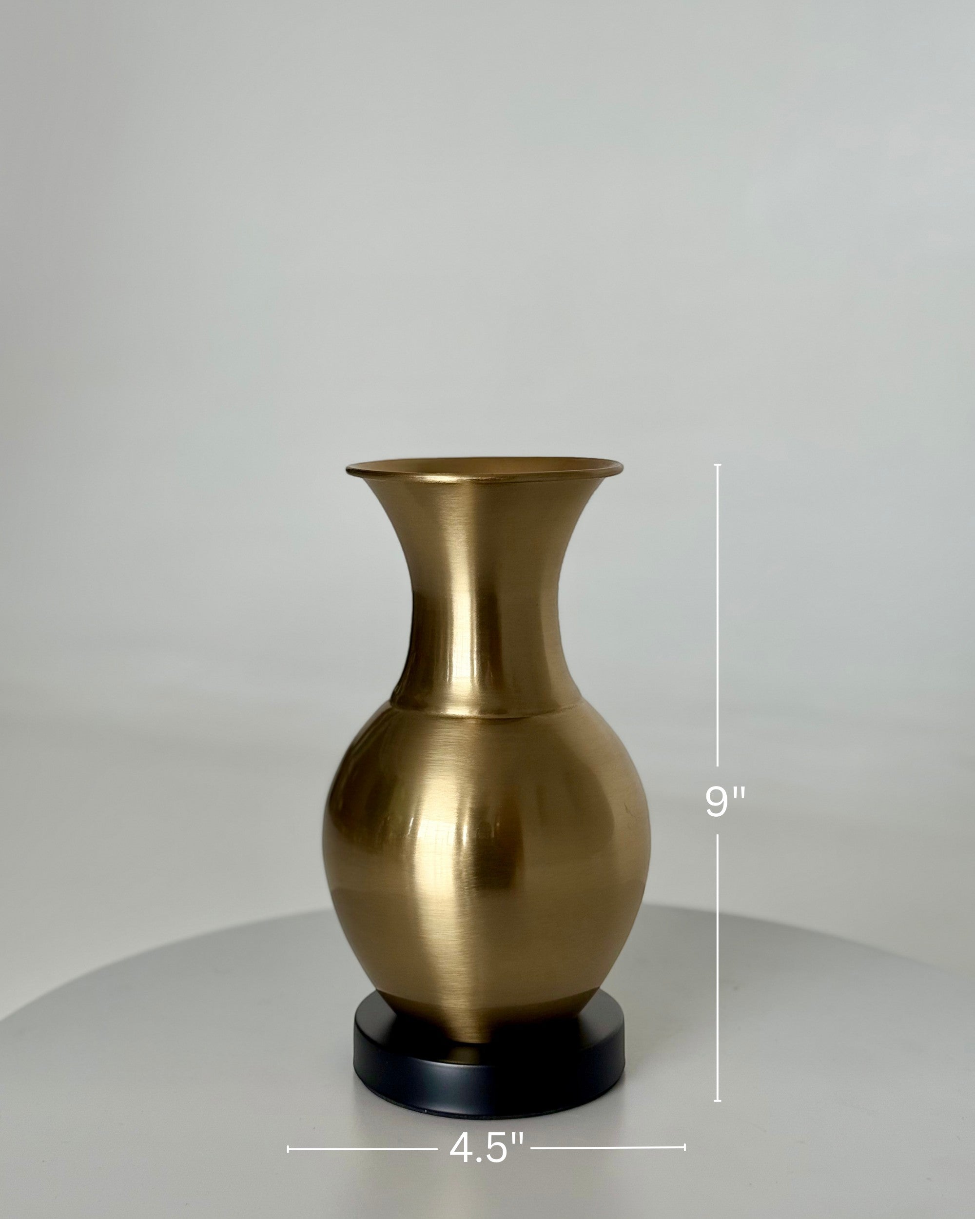 High Objects Aurelia Vase, brushed gold metallic finish, rounded body, flared neck, on black base. 9" H x 4.5" W.